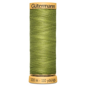 May include: A spool of olive green Gütermann thread. The spool has a tan top and bottom, with the brand name and thread length details printed on it. The thread is tightly wound, and the label indicates 100 meters of thread.