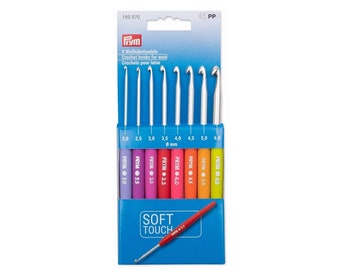 Könnte beinhalten: Ein Set von acht Häkelnadeln für Wolle, mit Größen von 2,0 mm bis 6,0 mm. Die Häkelnadeln haben silberfarbene Metallspitzen und farbige, ergonomische Griffe. Die Verpackung enthält die Marke "PRYM" und den Text "SOFT TOUCH".