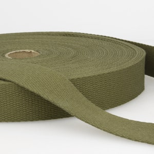 Peut inclure: Un rouleau de sangle en coton vert olive, un type de ruban en tissu résistant utilisé pour les sangles, les ceintures et autres applications.