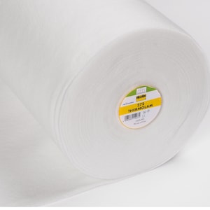May include: A white roll of 272 ThermOlam interfacing fabric. The label is yellow with black text and a barcode. The label reads "272 ThermOlam 100% PES 90 cm x 25 m."