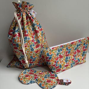 Könnte beinhalten: Eine weiße Keramik-Tasse mit schwarzem Henkel und dem Text "But First, Coffee" in schwarzer, handschriftlicher Schrift. Die Tasse steht auf einer weißen Oberfläche.