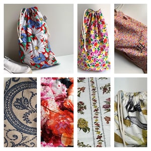 Könnte beinhalten: Sammlung von Kordelzugbeuteln in verschiedenen Blumenmustern. Eine Tasche zeigt große weiße Gänseblümchen, blaue Akzente und einen roten Hintergrund. Eine andere zeigt eine lebendige Mischung aus rosa, gelben und lila Blumen. Weitere Muster sind ein Blumendruck und ein Paisley-Design.