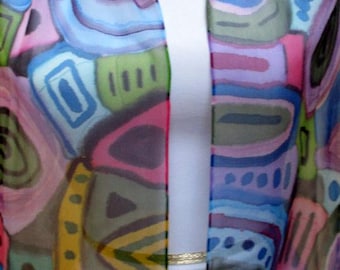May include: A colorful silk scarf with an abstract design. The scarf features a variety of shapes and colors, including blue, pink, green, and yellow. The scarf is draped over a white form, showcasing its vibrant pattern.