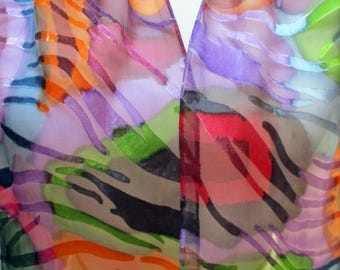 May include: A colorful silk scarf with a geometric pattern in shades of pink, orange, green, blue, and purple.