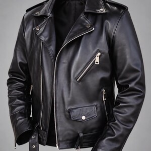 Könnte beinhalten: Eine schwarze Motorradjacke aus Leder mit breitem Reverskragen, silberfarbenen Metallreißverschlüssen, diagonalem Frontverschluss, einer kleinen Pattentasche mit Druckknopf und einem verstellbaren Gürtel mit Schnalle am Saum.