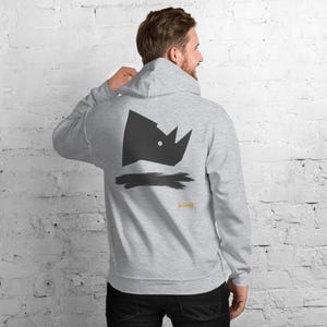 May include: A light gray hooded sweatshirt featuring a black geometric rhinoceros head graphic on the back. Below the rhinoceros, there is a black horizontal brushstroke design and the yellow text "No Comment" printed in a small, stylized font.