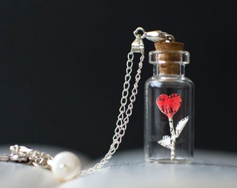 Collar con colgante de corazón pequeño en una botella