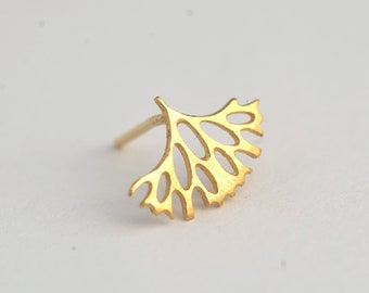 May include: A gold-colored earring with a delicate, intricate design resembling a leaf or branch. The earring is made of metal and has a post backing.