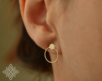 May include: Gold hoop earrings with a small circle attached to the top of the hoop.