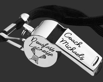 May include: A silver whistle with a black lanyard. The whistle has the words "Coach Michaels" engraved on the side and "Douglass Lacrosse" with a lacrosse graphic on the disc.