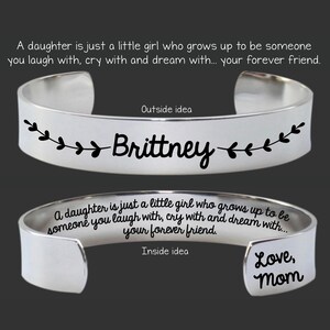May include: Silver bangle bracelet with the name "Brittney" engraved on the outside and the text "A daughter is just a little girl who grows up to be someone you laugh with, cry with and dream with... your forever friend." and "Love, Mom" engraved on the inside.