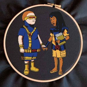 May include: Embroidered artwork featuring two figures, one in a blue and yellow costume with a yellow helmet and the other in a yellow and blue costume with a black headband. The figures are holding hands.