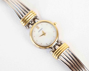 Vintage tweekleurige Seiko met een wit rond gezicht - (werkende batterij)