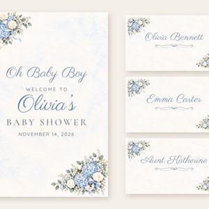 May include: A baby shower welcome sign and three place cards featuring blue hydrangea and white rose floral arrangements. The text reads Oh Baby Boy Welcome to Olivia's Baby Shower November 14, 2026, with names Olivia Bennett, Emma Carter, and Aunt Katherine.