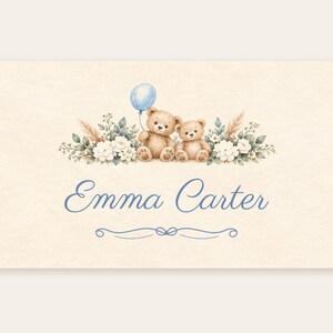 May include: A rectangular card featuring the name Emma Carter in blue script text. Above the name are two brown teddy bears, one holding a light blue balloon, surrounded by white flowers, green leaves, and beige pampas grass.