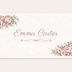 May include: A rectangular card featuring the name Emma Carter in a pink cursive script. The design includes floral arrangements of pink roses and green leaves in the top-left and bottom-right corners, with a decorative pink flourish below the name.