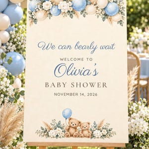 May include: A rectangular baby shower welcome sign featuring a cream background, blue and beige balloon illustrations, floral accents, and two teddy bears. The text reads: We can bearly wait, WELCOME TO Olivia's BABY SHOWER, NOVEMBER 14, 2026.