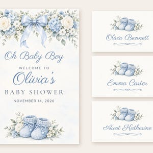 Pu&ograve; includere: Un invito per baby shower e tre segnaposto con illustrazioni ad acquerello di scarpine lavorate a maglia blu, rose bianche e ortensie blu. Il testo recita: Oh Baby Boy WELCOME TO Olivia's BABY SHOWER NOVEMBER 14, 2026, Olivia Bennett, Emma Carter e Aunt Katherine.