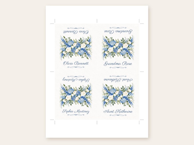 May include: A sheet of four rectangular paper labels featuring a floral arrangement of blue delphiniums and white roses. Each label displays a name in blue script: Olivia Bennett, Grandma Rose, Sophia Martinez, and Aunt Katherine.