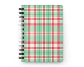 May include: A spiral-bound notebook featuring a plaid pattern with intersecting lines in shades of mint green, cream, and red. The cover has a consistent grid design throughout, and the black metal wire binding is located along the left side.
