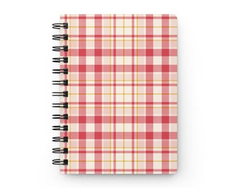 May include: A spiral-bound notebook featuring a red, white, and yellow plaid pattern. The cover displays a repeating grid of vertical and horizontal lines in varying thicknesses, secured on the left side by a black metal wire coil binding.