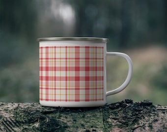 May include: A white enamel mug featuring a red and yellow plaid pattern. The mug has a smooth cylindrical body, a curved handle on the right side, and a metallic silver rim along the top edge, providing a clean and functional design.