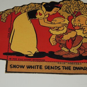 May include: A vintage paper doll set featuring Snow White and the Seven Dwarfs. Snow White is dressed in a yellow dress and black bodice, and she is bowing to the dwarfs. The dwarfs are wearing brown pants and red shirts. The paper doll set is printed on a red background with a yellow border. The text "Snow White Sends the Dwarfs Off" is printed on the bottom of the paper doll set.