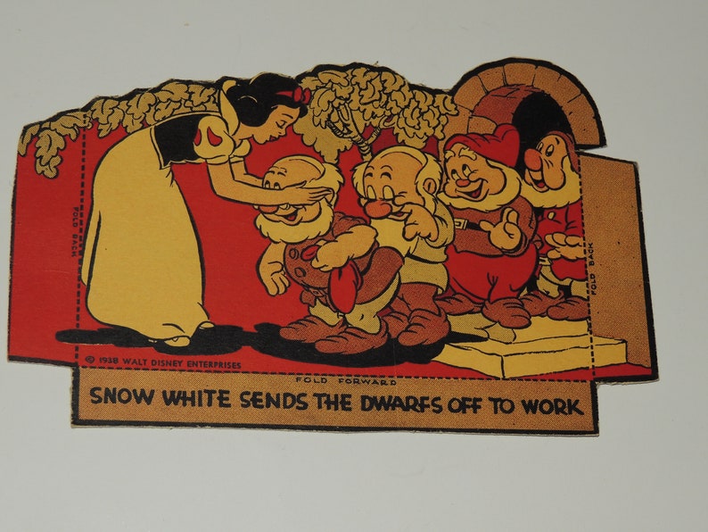 May include: Snow White, dressed in a yellow dress and red cape, is saying goodbye to the seven dwarfs. The dwarfs are wearing brown pants and shirts, and red hats. The dwarfs are standing on a platform, and Snow White is standing on the ground. The text on the image reads "1938 WALT DISNEY ENTERPRISES", "FOLD FORWARD", "SNOW WHITE SENDS THE DWARFS OFF TO WORK", and "FOLD BACK".