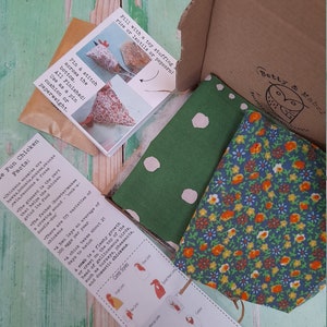 Puede incluir: Una tela verde y blanca con lunares blancos y una tela floral azul y naranja. Las telas est&aacute;n en una caja de cart&oacute;n con una nota que dice "&iexcl;Rellena con un relleno de juguete: arroz o lentejas o palomitas!" y "Datos divertidos sobre las gallinas: Los enemigos de las gallinas son los halcones, los linces, las serpientes, las mofetas, los b&uacute;hos, los mapaches y los zorros. La molleja es la parte que ayuda a la gallina a moler su comida. El padre (gallo) hace un sonido de canto de gallo, cock-a-doodle-doo. Hay 175 variedades de gallinas. Una gallina pone un promedio de 300 huevos por a&ntilde;o. Un pollito tarda unos 21 d&iacute;as en eclosionar. Una cresta es un crecimiento carnoso o una cresta en la parte superior de la cabeza de las aves galliformes, como los pavos, los faisanes y las gallinas dom&eacute;sticas. Estilos de cresta: Cresta simple, Cresta de rosa, Cresta en V, Cresta de bot&oacute;n de oro, Cresta de fresa y Cresta de gorri&oacute;n."