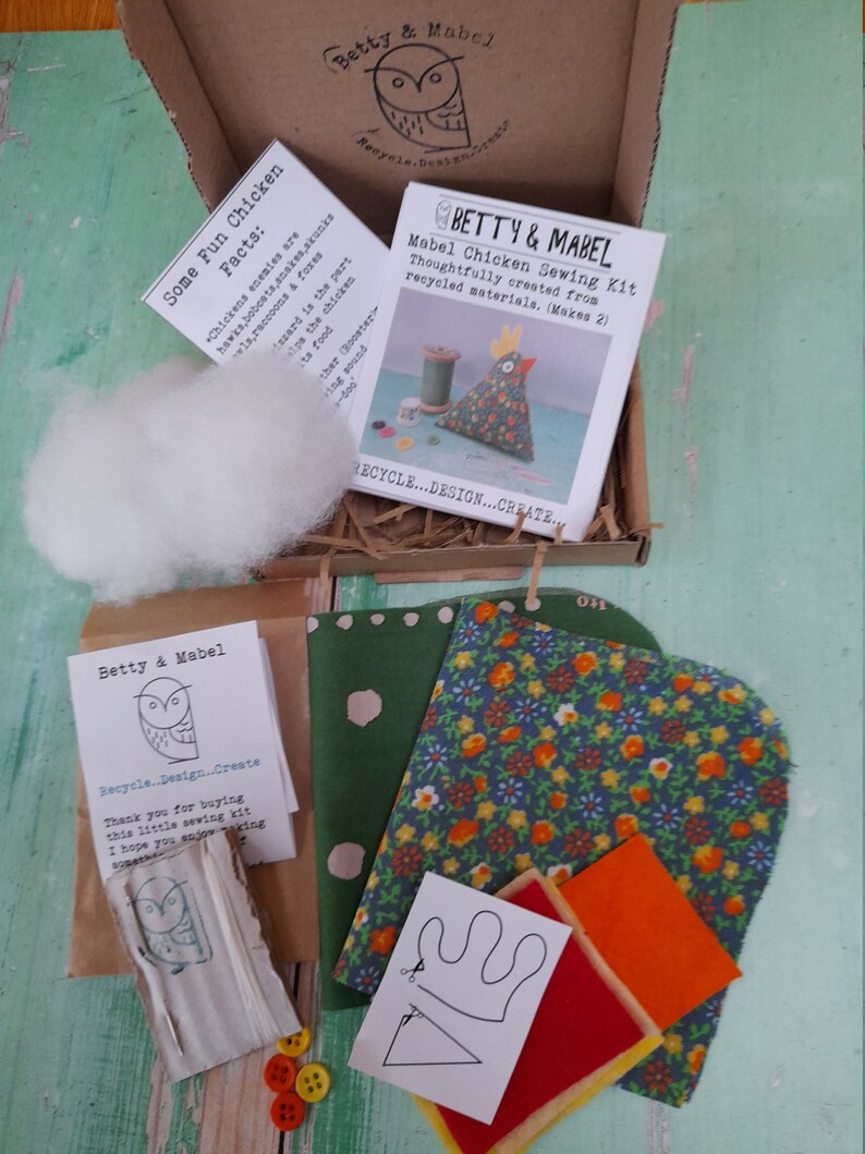 Puede incluir: Un kit de costura para hacer dos juguetes de pollo de fieltro. El kit incluye recortes de tela, fieltro, botones, hilo y un patr&oacute;n. El kit est&aacute; empaquetado en una caja de cart&oacute;n marr&oacute;n con una etiqueta blanca que dice "Betty & Mabel Mabel Chicken Sewing Kit Thoughtfully created from recycled materials. (Makes 2)"
