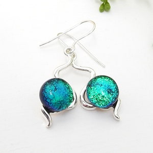 May include: Silver dangle earrings with green and blue dichroic glass round beads.