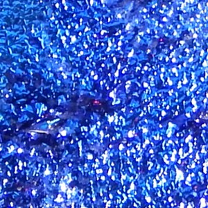 Puede incluir: Primer plano de una tela azul con purpurina con un acabado brillante e iridiscente.