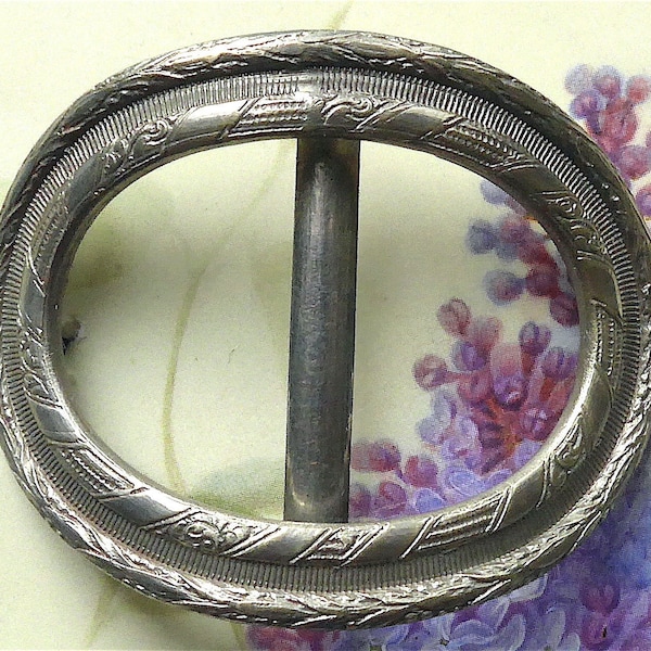 Shoe buckle, antique.   An attractive chased metal buckle, oval shaped with a classical design, white metal. c1890-1910.