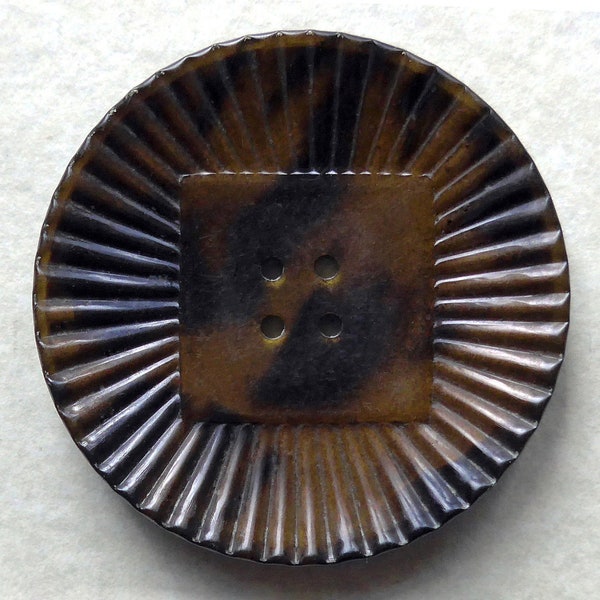 Celluloid button, vintage.  A radiating design with a central square, intermixed tan & black, metal reverse, 4 hole sew-thru. c1920's.