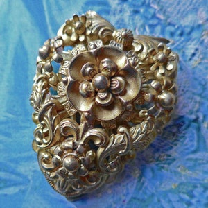 Dress clip, vintage.  Floral with an ornate design, pressed metal & very rococco.   c1920.