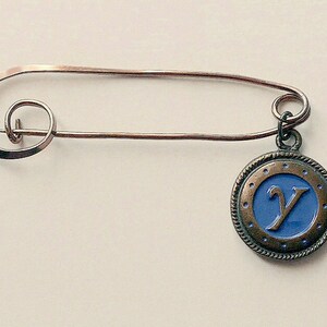 Brooch, featuring the letter &#39;Y&#39; in a pendant.  A neat swirl of metal with a dangling pendant, blue with the letter &#39;L&#39;.  c1980&#39;s.