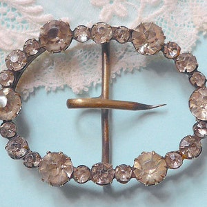 Diamante buckle, antique.  Oval, horizontal with claw set diamante in two sizes, swivel chape. c1900.