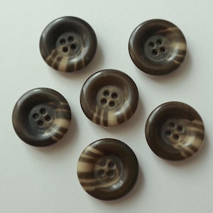 May include: Six brown and white striped buttons with four holes each.