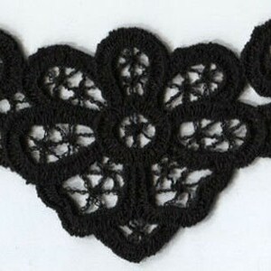 Puede incluir: Borde de encaje negro con un diseño floral. El encaje es delicado e intrincado, con un borde festoneado.
