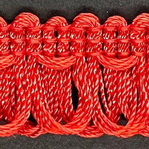 May include: Red braided trim with a decorative looped pattern. This trim is perfect for adding a touch of elegance to any project.