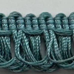 May include: Teal blue decorative trim with a looped design. The trim is made of a woven fabric and has a soft, textured feel.