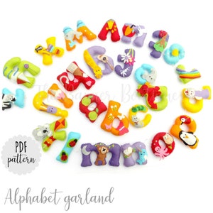 Könnte beinhalten: Eine bunte Filz-Alphabetgirlande, wobei jeder Buchstabe mit einem anderen Tier oder Objekt verziert ist. Die Buchstaben sind in einem Kreis auf weißem Hintergrund angeordnet. Der Text "PDF pattern" ist in der linken unteren Ecke des Bildes sichtbar. Der Text "Alphabet garland" ist in der unteren Mitte des Bildes sichtbar.