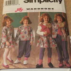 May include: Simplicity sewing pattern for a girl's wardrobe. The pattern includes a dress, a top, pants, a skirt, and a vest. The pattern is for sizes 5-6X. The pattern is called "Jiffy Wardrobe" and features a girl wearing the different pieces of clothing.