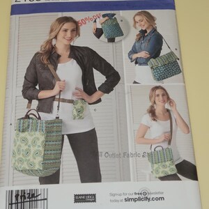 May include: Simplicity sewing pattern 2168 featuring a tote bag, crossbody bag, and small pouch. The bags have a paisley and striped pattern in shades of green, blue, and cream. The pattern includes the text "ONE SIZE" and "50% OFF".