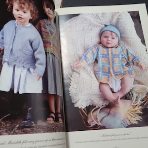 May include: Image from a vintage knitting pattern book featuring children's knitwear. A baby wears a blue and yellow plaid cardigan and matching hat. Two children stand nearby, one in a blue cardigan and white dress, the other in a patterned sweater.