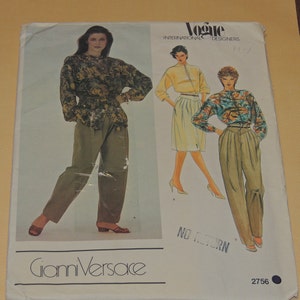 May include: A vintage Vogue International Designers sewing pattern featuring Gianni Versace designs. The pattern shows illustrations of women's clothing, including a floral print blouse, pleated pants, and a skirt suit. The pattern number is 2756.