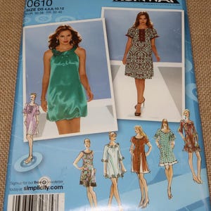 May include: A Simplicity sewing pattern featuring images of dresses. The pattern includes a green satin dress and other designs. The pattern number is 0610, with sizes D5 4,6,8,10,12. The Project Runway logo is visible.