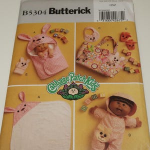 May include: A sewing pattern for Cabbage Patch Kids clothing. The pattern includes instructions for making a hooded bunny outfit, a bib, a tote bag, and a pair of booties. The pattern is from Butterick and has the number B5304.