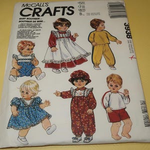 May include: A McCall's Crafts pattern envelope featuring illustrations of baby clothing designs. The designs include dresses, rompers, and a jogging suit. The text on the envelope reads "Baby Boutique" and includes French translations.