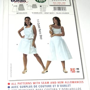 May include: A white wrap skirt sewing pattern from Burda Easy, model 7964. The pattern includes sizes 10-22 and features a wrap skirt design. The image also shows a woman wearing a white skirt and top.